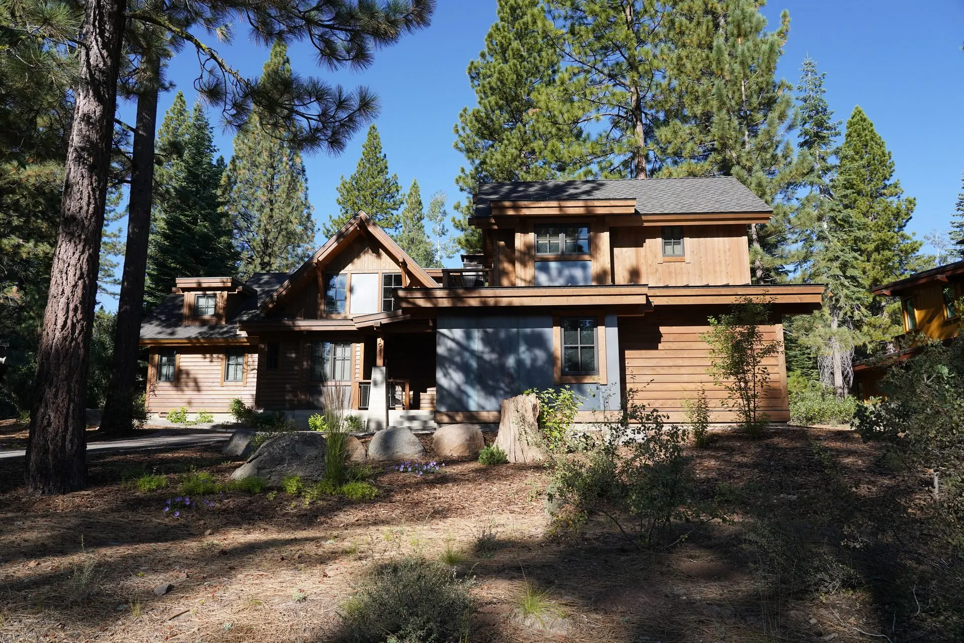 Rustic custom mountain home exterior with graded site