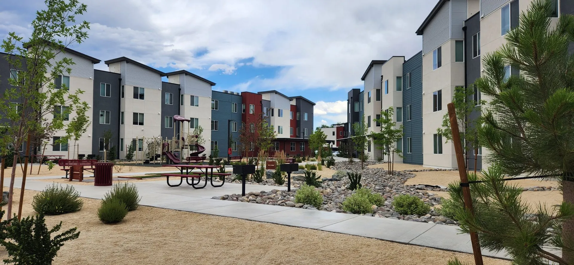 Apartment courtyard with hardscape, landscaping, and accessible pedestrian routes